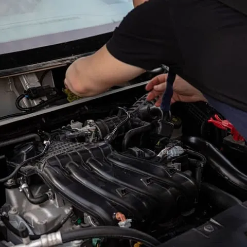 A mobile mechanic working under a car
